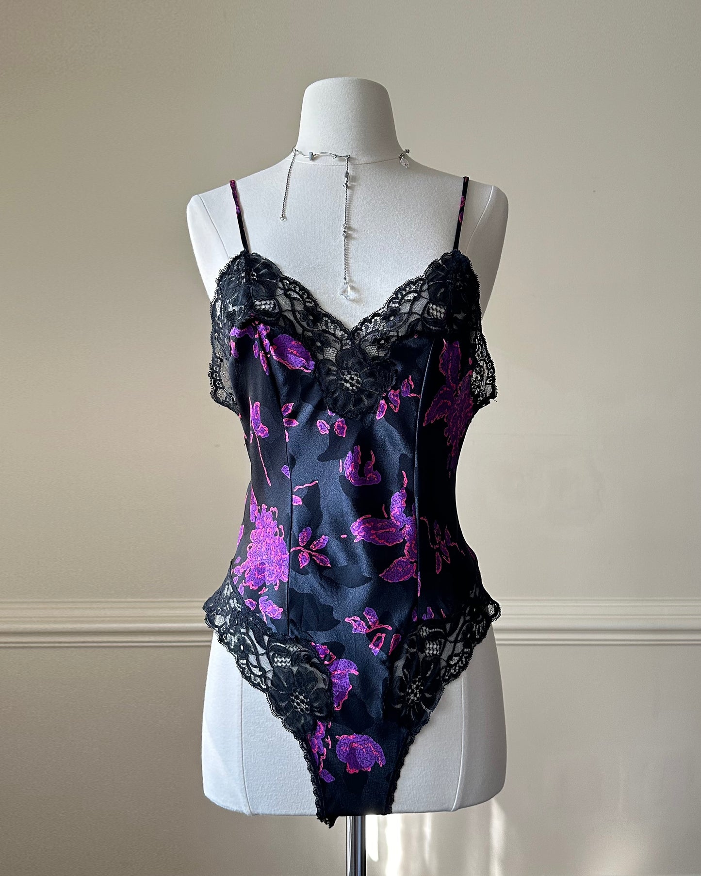 Vintage DIOR’s satin black bodysuit featuring vibrant purple floral prints