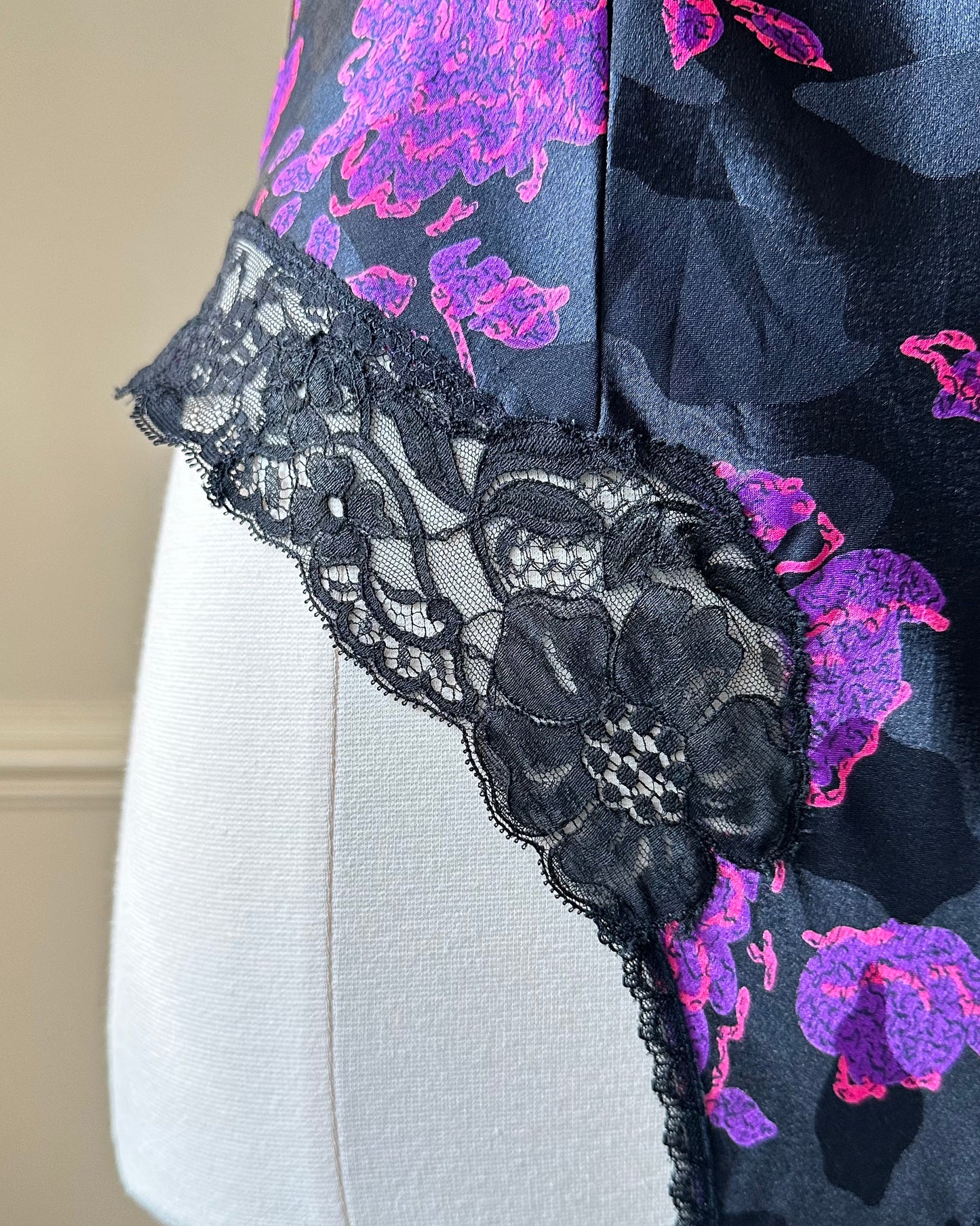 Vintage DIOR’s satin black bodysuit featuring vibrant purple floral prints