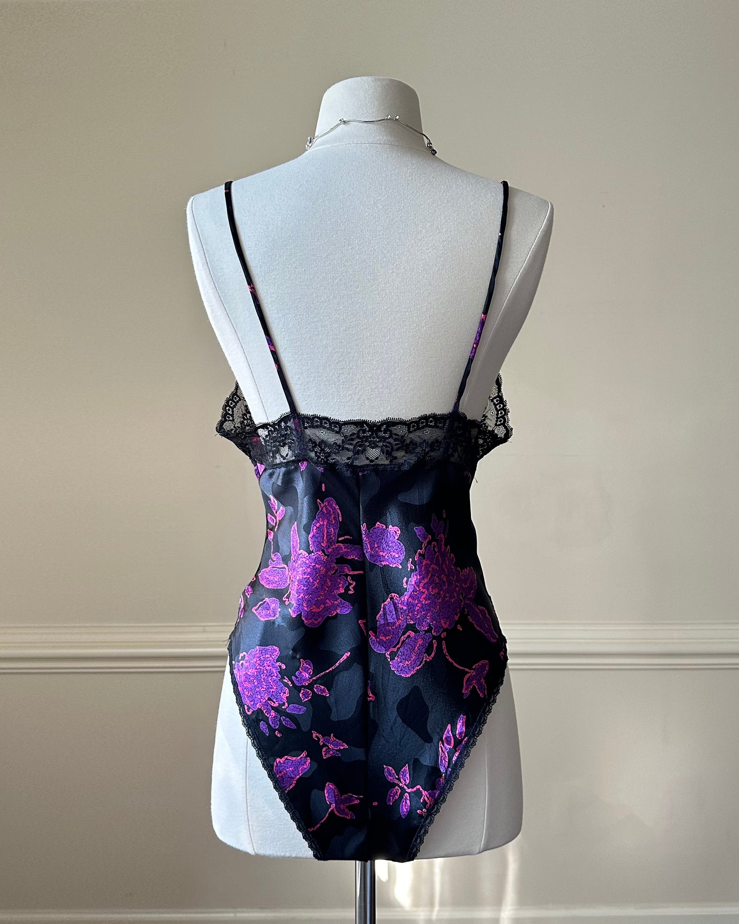 Vintage DIOR’s satin black bodysuit featuring vibrant purple floral prints