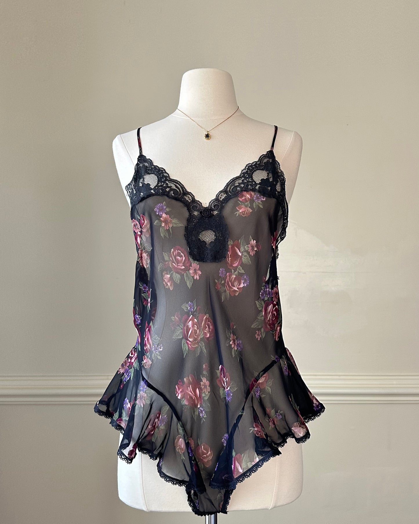 Flirty sheer black bodysuit featuring rose bouquets print with flared hips