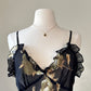 Sultry sheer black slip dress featuring golden blooming flowers print