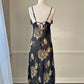 Sultry sheer black slip dress featuring golden blooming flowers print