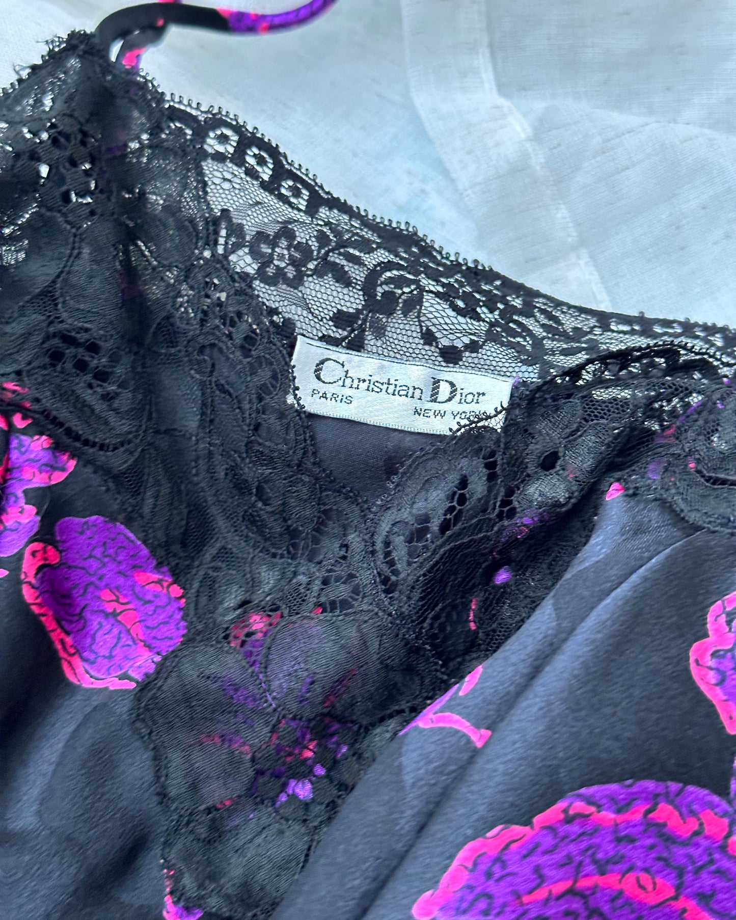 Vintage DIOR’s satin black bodysuit featuring vibrant purple floral prints