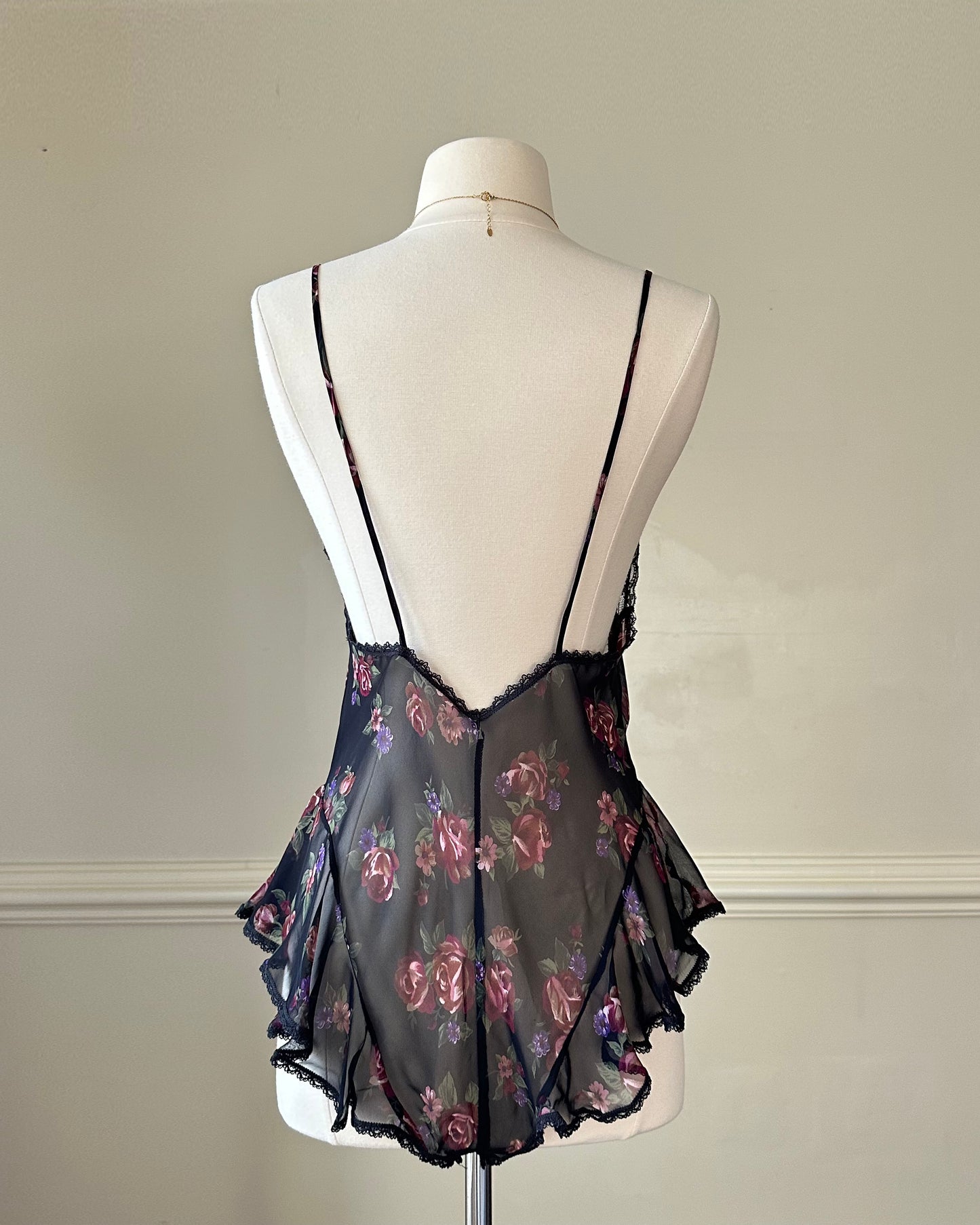 Flirty sheer black bodysuit featuring rose bouquets print with flared hips